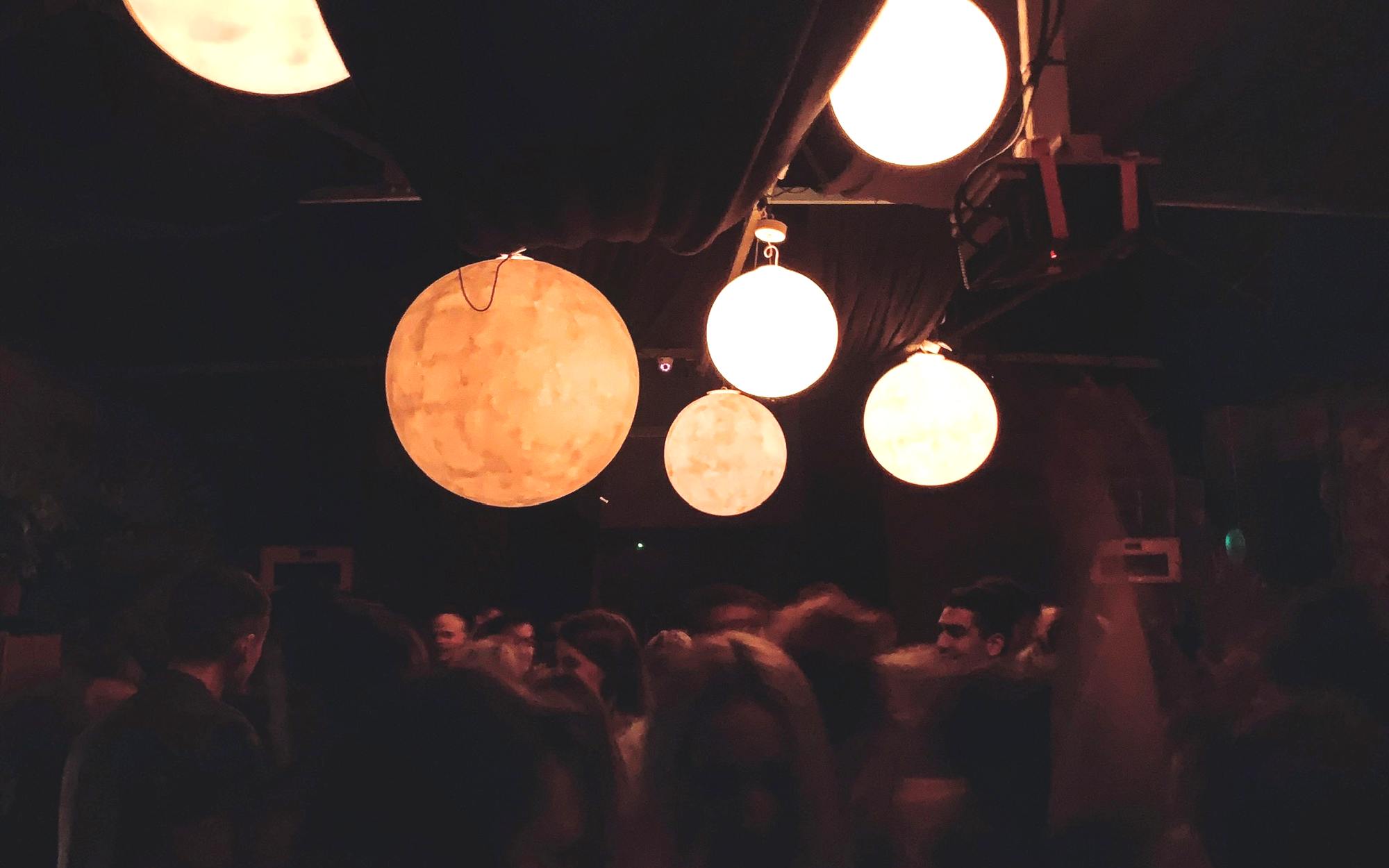 Glowing globe fixtures hung low over a full dancefloor